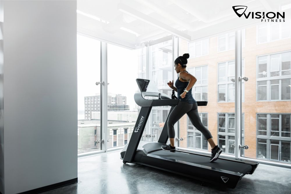 Eine Frau läuft auf einem Laufband in einem Fitnessstudio und konzentriert sich auf ihr Training.
